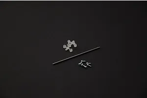 Small plastic parts sprue, metal axle rod, and four screws on a dark background for Italeri model kit.