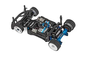High angle studio shot of an assembled 1/28 scale electric RC car chassis showing carbon fiber and blue anodized parts against a white background.