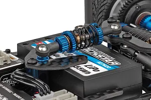 Close-up of the blue anodized aluminum shock absorber and black LiPo battery mounted on an RC car chassis.