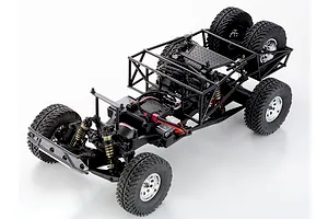 Top-down studio shot of the Kyosho Outlaw Renegade 2RSA RC truck chassis showing roll cage, dual rear spare tires, and suspension.
