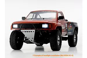 Front three-quarter view of the Kyosho Outlaw Renegade RC truck featuring illuminated headlights on a white background.