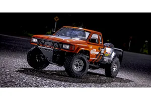 Kyosho Outlaw Renegade 2RSA RC Short Course Truck parked on an outdoor paved surface at twilight.