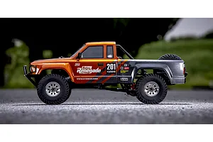 Kyosho Outlaw Renegade 1/10 scale electric RC short course truck photographed from the side on an outdoor surface