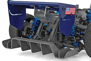 Close-up rear view of an RC car showing a large blue wing, grey diffuser, and blue aluminum shocks.