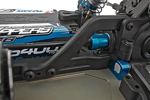 Close-up studio view of the RC car chassis showing suspension arms, blue anodized parts, and a mounted battery pack.