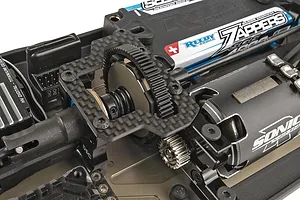 Close-up of the carbon fiber slipper clutch assembly and central drivetrain components installed on a 1/10 scale electric RC buggy chassis.