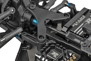 Close-up studio view of the chassis, steering linkage, and internal components on the Team Associated RC10B84.1 RC buggy.