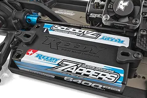 Close-up of a Reedy Zappers battery installed in a Team Associated RC car chassis with blue hardware.