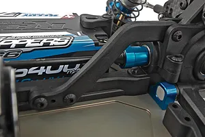 Close-up of RC buggy chassis showing black plastic suspension arm, blue anodized aluminium hardware, and a branded LiPo battery.