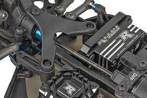 Top down studio view of RC buggies steering servo, linkages and chassis components.