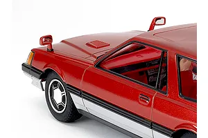 Close-up of the front quarter and interior of a painted red scale model car against a plain white background.