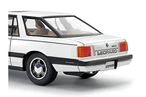 Rear quarter view of assembled white Tamiya 1/24 Nissan Leopard scale model car kit with driver figure visible.