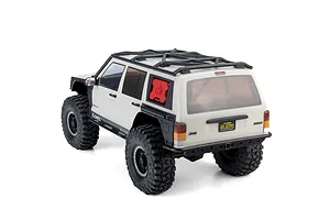 Rear three-quarter view of the Axial SCX10 III Jeep Cherokee XJ RC rock crawler in white with a roof rack and red fuel can.