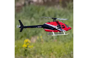 Blade Jet Ranger 235CP RC helicopter in flight outdoors against a green grassy background.