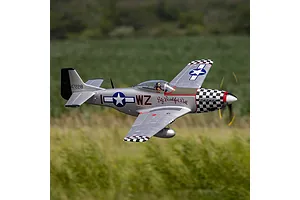 E-Flite P-51D Mustang Big Beautiful Doll RC fighter plane flying outdoors above a grassy field.