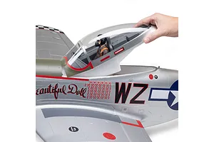A human hand lifting the clear canopy hatch on the silver E-Flite P-51D Mustang RC airplane, showing the pilot figure inside.