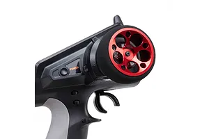 Close-up of a red aluminium wide circle steering wheel installed on a black RC transmitter against a white background.