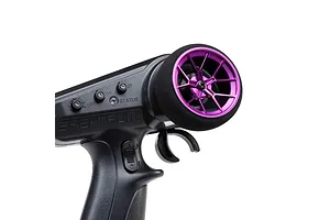 Close-up of a purple aluminium wide spoke transmitter wheel installed on a black RC transmitter against a white background.