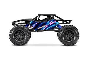 Side profile of Traxxas RC rock crawler featuring a black tubular frame, blue and pink body panels, and large treaded tires.