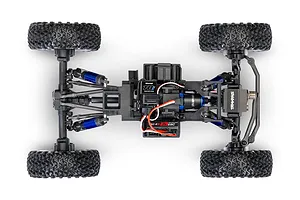 Top-down studio view of the chassis, suspension, receiver, and ESC of a Traxxas TXC-4M RC crawler.
