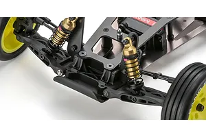 Close-up studio shot of the front suspension, gold shock absorbers, chassis, and yellow wheels on an RC buggy.