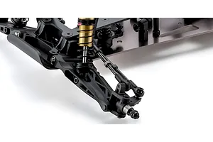 Close-up studio view of the front suspension, metal shock absorber, and chassis of the Kyosho Ultima Pro RC buggy kit.