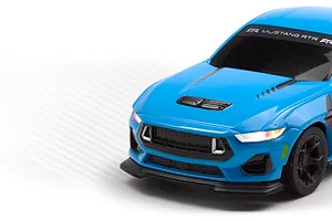 Close-up of the front end of a blue HPI Nano-TTR Ford Mustang RC car with illuminated headlights against a white gradient background.