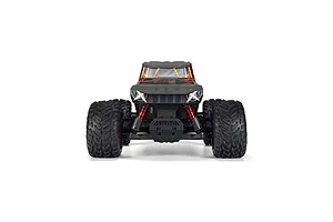 Front view of the ARRMA Quake 4S RC monster truck on a white background, showcasing its aggressive front grille, red shocks, and large tires.