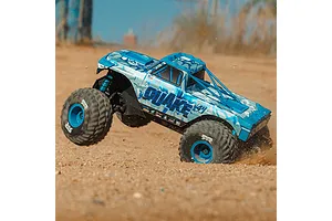 ARRMA Quake 4S RC monster truck in action kicking up dirt on an outdoor dirt track with a blue and white body shell.