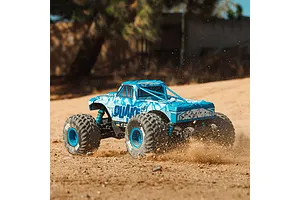 ARRMA Quake 4S blue monster truck kicking up dirt and sand in action on an outdoor dirt track.