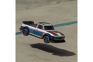 ARRMA Infraction 3S RC truck jumping mid-air over a concrete surface with blue line markings.