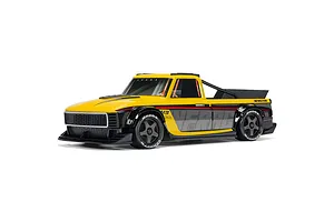 ARRMA Infraction Grom 3S yellow and black RC street truck in studio setting, angled front three-quarters view.