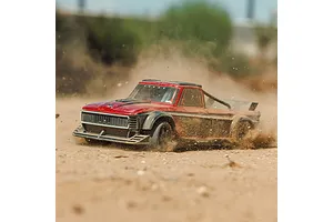 ARRMA Infraction Grom RC street truck drifting and kicking up dust on an outdoor dirt track.