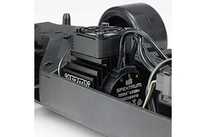 Close-up of the brushless motor and cooling fan mounted inside the chassis of an ARRMA RC car.