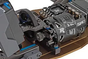Close-up of the electric motor, transmission gears, and carbon fiber top plate installed on an RC chassis.