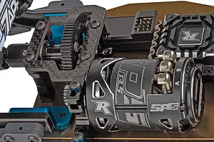 Close-up of Reedy electric motor and carbon fiber chassis components on an RC car.