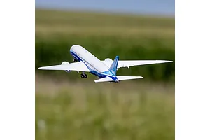 E-Flite Micro Boeing 787 Dreamliner RC airplane in flight against a green and blue outdoor background.