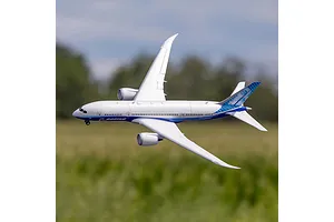 E-Flite Micro Boeing 787 Dreamliner RC airplane in flight against an outdoor field and sky background.