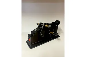 Black TK Racing Tyre Prep and Break In Machine viewed from an angle against a plain white background.
