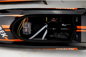 Top-down view of the open hull interior of the Atrek Stealth RC boat, showing electronics, cooling lines, and motor mount.