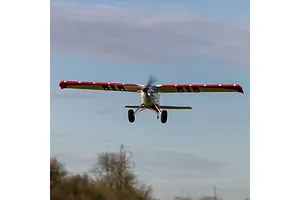 E-Flite Turbo Timber Evolution RC plane flying overhead in a clear sky with landing gear visible.