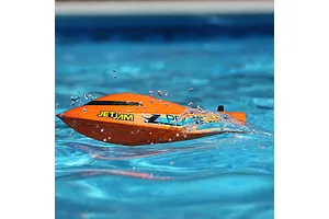 Pro Boat Jet Jam V2 orange RC speed boat speeding across clear blue pool water with splashing spray.