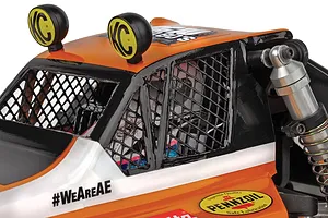 Close-up of the orange and white body, KC HiLites roof lights, and window nets of the Team Associated RC10 Ultra Rider buggy.