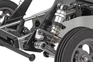 Close-up of front suspension, carbon fibre shock tower, alloy shock absorber and linkages on a Team Associated RC car.