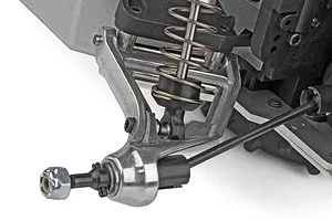 Close-up studio view of the RC buggy front suspension assembly including chrome-finished arm, shock absorber, and axle shaft.