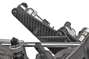 Close-up studio shot of a carbon fiber shock tower and suspension components on a Team Associated RC car.