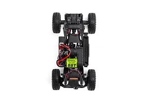 Top-down view of an Axial RC crawler chassis showing the frame, motor with green label, electronics, wiring, and four rubber tires against a white background.
