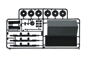 Black plastic model kit parts sprue containing wheel rims, axles, and structural components against a white background.
