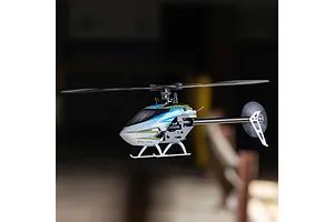 Blade Revolution 155 CP RC helicopter in flight against a dark indoor background