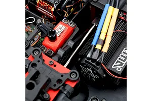 Close-up of an installed Method RC titanium centre front driveshaft in an RC vehicle chassis near electronic components.